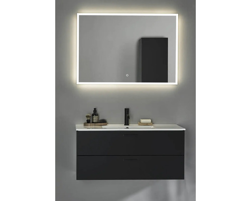 Badrum med tvättställsskåp, tvättställ och belyst spegel