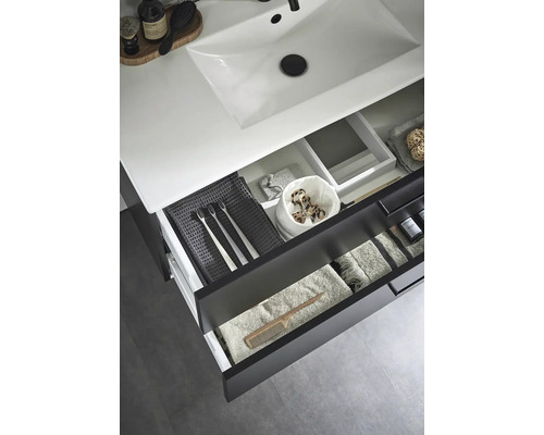 Badrum med handfat och öppna lådor med handdukar och badrumsartiklar