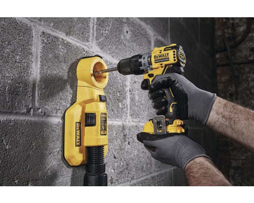 DeWalt borrmaskin med borr och dammutsug vid borrning i en vägg