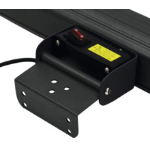 Detaljvy av ett svart lamphållare med strömbrytare och varning.