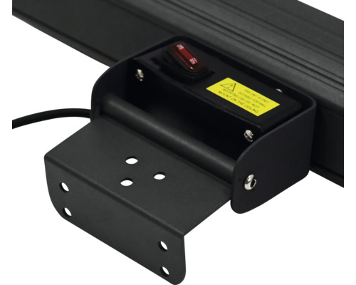 Detaljvy av ett svart lamphållare med strömbrytare och varning.