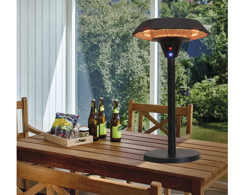 Terrass med terrassvärmare, träbord, stolar, drycker och snacks