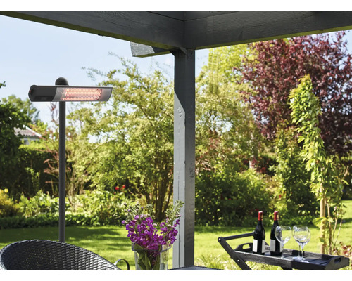 Terrass med terrassvärmare, bord och drycker i trädgården