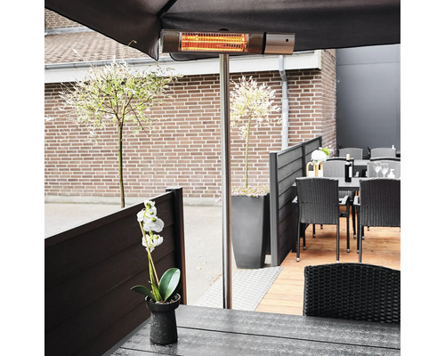 Terrassscen med terrassvärmare under ett parasoll, bord och stolar