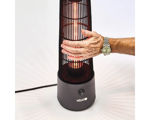 Närbild av en person som rör en uteplatsvärmare, med fokus på värmaren och handen