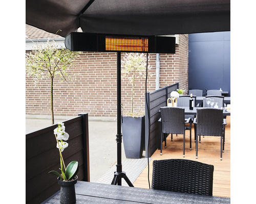 Terrass med värmelampa på stativ och trädgårdsmöbler