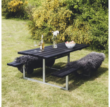 Svart picknickbordsset i trä med stålram, dekorerad med drycker, blomvas, fruktskål och skinn i trädgården.
