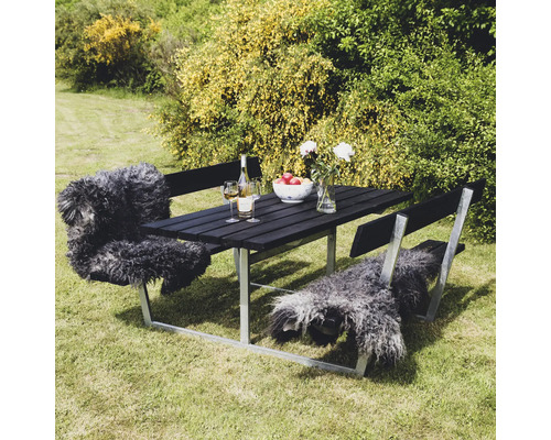 Trädgårdsscen med matbord i trä och metall på gräsmatta