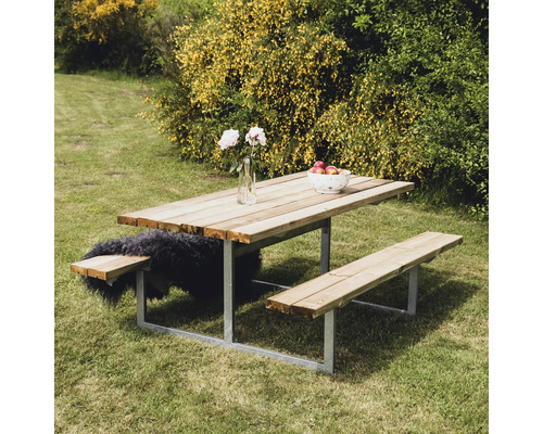 Picknickbord med bänkar av trä och metall i trädgården