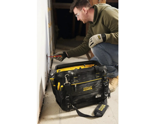 Hantverkare som arbetar med skruvmejsel och verktygsväska inomhus