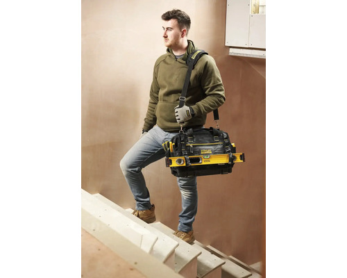 Hantverkare med verktygsväska som går uppför trappan