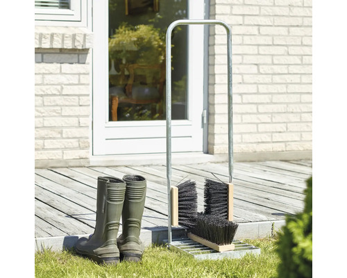 Gummistövlar och stövelrengörare med borstar framför huset