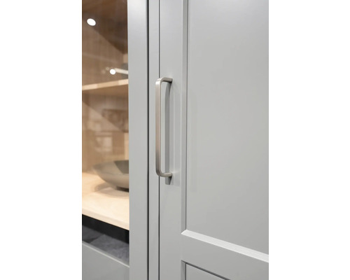 Detaljbild av ett grått skåp med ett avlångt, silverfärgat handtag