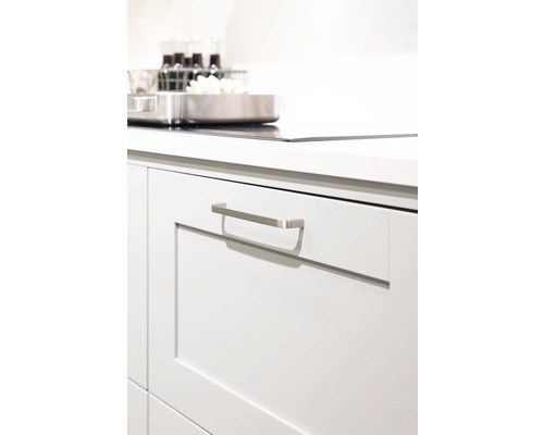 Detaljvy av en vit kökslåda med metallhandtag