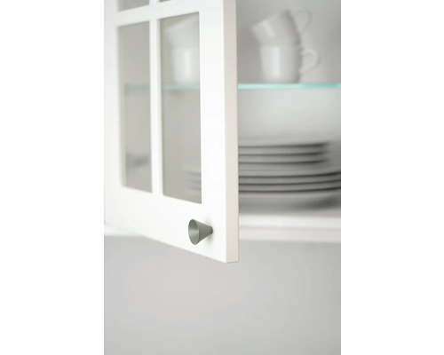 Detaljbild av ett öppet köksskåp med porslin och ett koniskt handtag