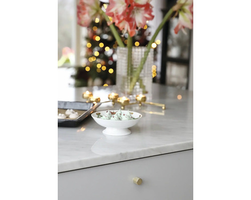 Festligt inredd köksbänk med amaryllis, ljus och bakverk för julen.