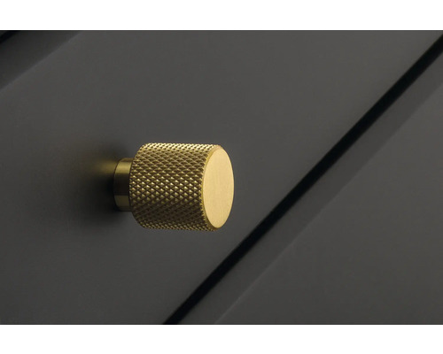 Detaljbild av en möbelknapp i metall med räfflad yta