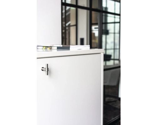 Närbild av ett vitt skåp med T-format handtag