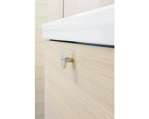 Detaljvy av ett underskåp för tvättställ med handfat och handtag