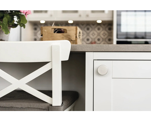 Detaljvy av ett ljust kök med sittplatser och kökselement