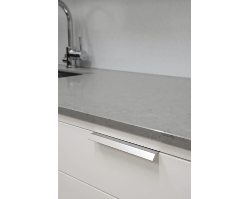 Köksscen med diskbänksblandare, bänkskiva och skåp med grepplist