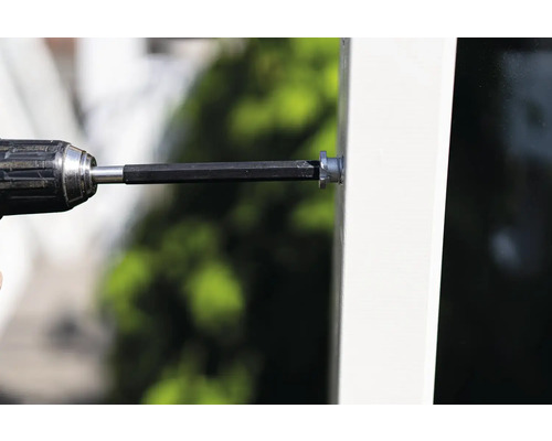 Borrmaskin med borr fäster skruv i fönsterkarm