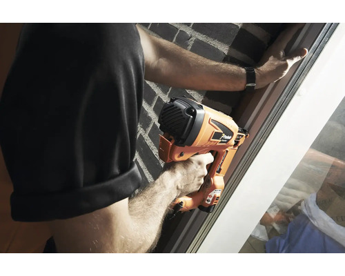 En person använder en batteridriven spikpistol på en fönsterkarm.