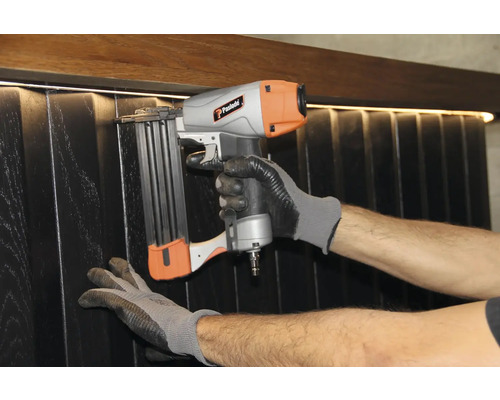 Hantverkare fäster paneler med en pneumatisk spikpistol