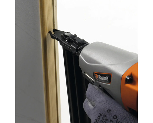 En person fäster en träbit med en Paslode-spikpistol.