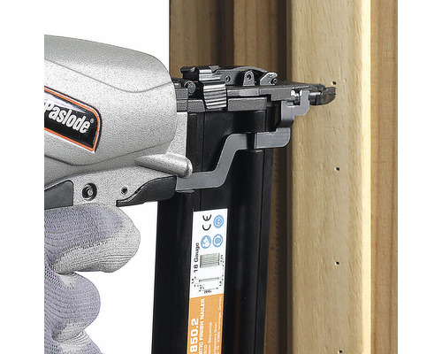 Paslode logotyp. Hantverkare med tryckluftsdriven spikpistol som fäster en träbit.