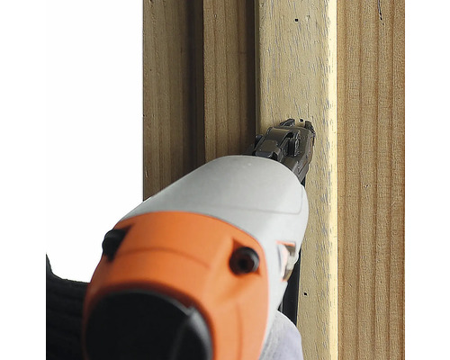 En spikpistol fäster en träbräda.