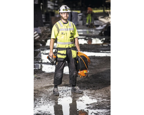 Hantverkare med tryckluftspikpistol och kompressor på en byggarbetsplats