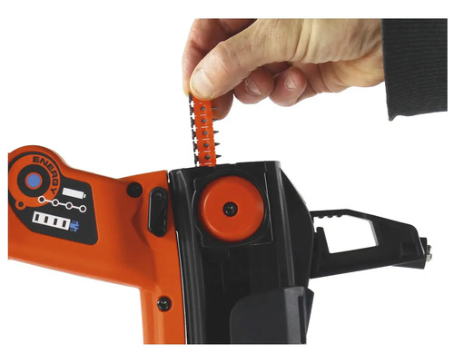 En person placerar en remsa med spikar i en orange och svart spikpistol.