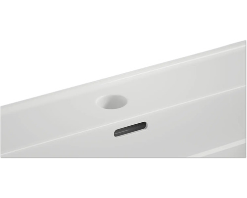 Detaljvy av ett handfat med kranhål och överfyllnadsskydd