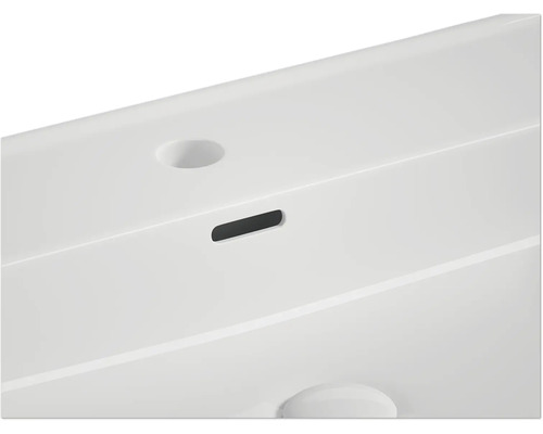 Detaljvy av ett tvättställ med överfyllnadsskydd och kranhål