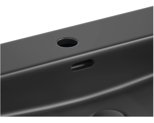 Detaljvy av en svart metallprofil med hål och försänkningar.