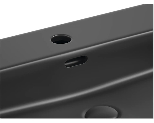 Detaljvy av ett handfat med kranhål och överfyllnadsskydd