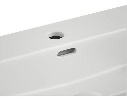 Detaljvy av ett tvättställ med kranhål och överlopp