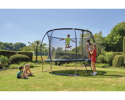 Trampolin med säkerhetsnät och barn i trädgården