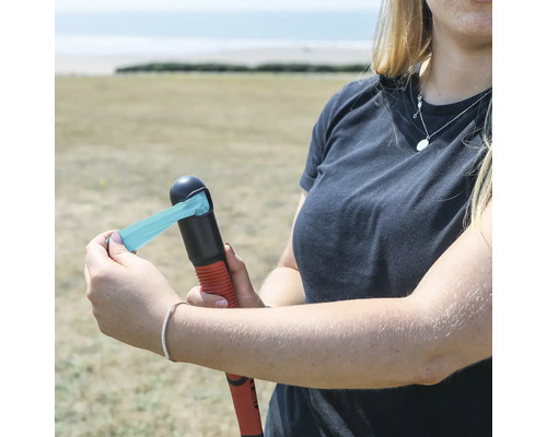 Kvinna tar ut en avfallspåse från hundavfallspåse-dispensern