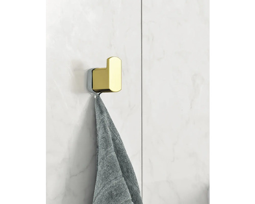 Handdukshängare av metall med handduk på en vägg