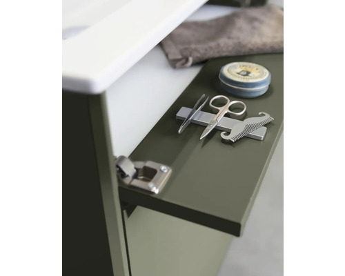 Detaljbild av ett badrumsskåp med pincett, nagelsax, skäggkam och pomada