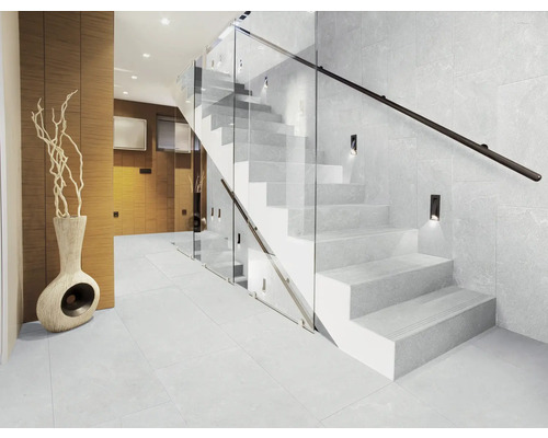 Modern trapphus med trappa, glasräcke, vägglampor och klinkergolv
