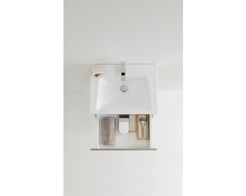 Tvättställsskåp med öppen låda och badrumsartiklar