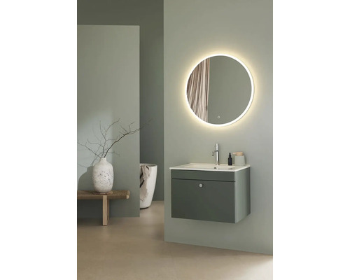 Badrum med tvättställ, rund spegel med belysning och dekoration