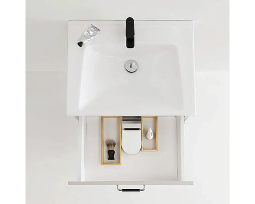 Tvättställ med öppen låda, som innehåller en rakborste, en tvåldispenser och en behållare