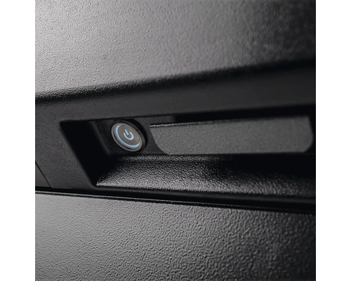 Närbild av en svart enhet med en rund strömbrytare