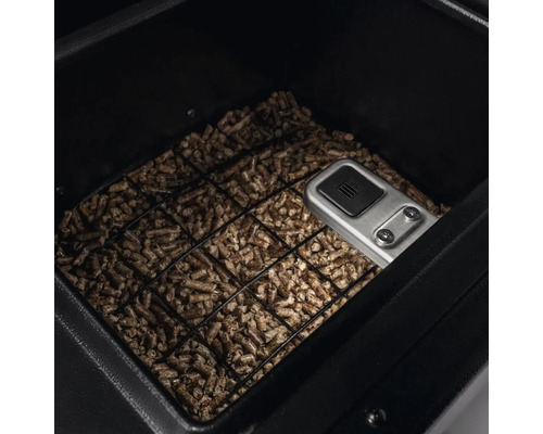 Pelletgrillens brännkammare fylld med pellets och manöverelement