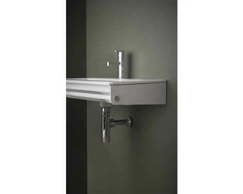 Vägghängd tvättställ med blandare och vattenlås.