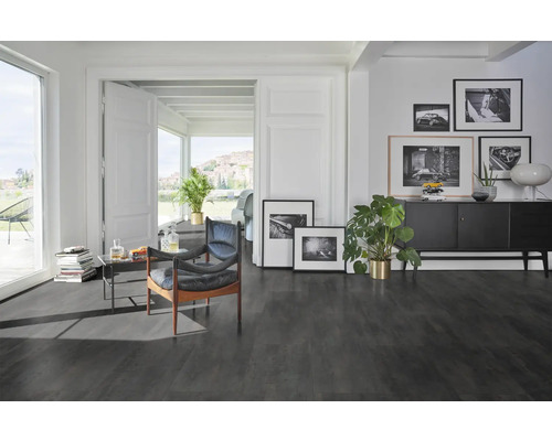 Modernt vardagsrum med mörkt golv, fåtöljer och dekorativa element